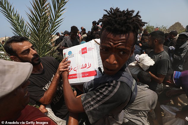 Palestinians collect aid packages dropped by parachutes from military cargo planes at the Nuseirat refugee camp in Deir al-Balah, Gaza on August 10, 2025