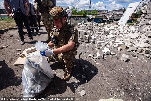 Trump's frustration with Putin has grown as the fighting has worn on months into his second term. A serviceman is pictured here collecting the wreckage of a Russian missile that hit a residential neighborhood in Kharkiv