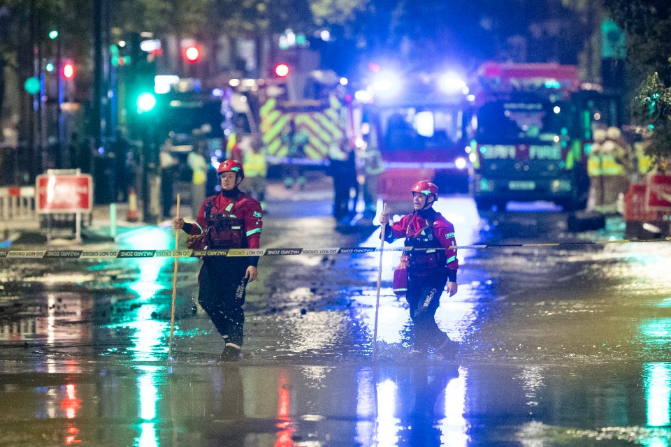 Emergency responders wading through floodwaters in London.