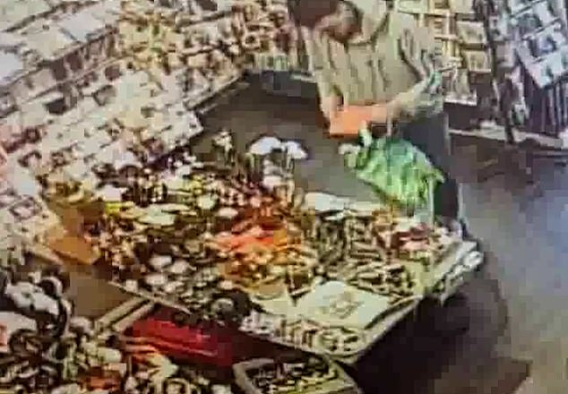 A man shoving luxury candles into an empty Waitrose bag in Hersham