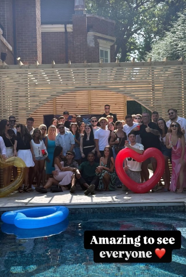 Large group photo of people by a swimming pool.