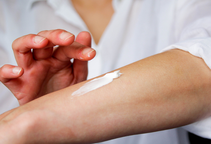 Person applying cream to their arm.