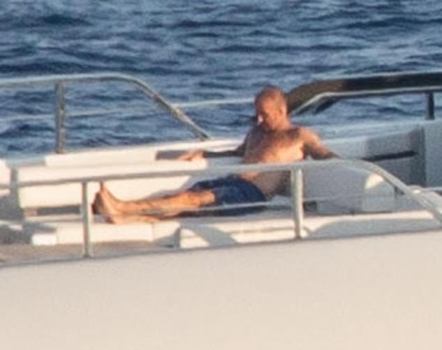 David, who was caught cheekily pinching his wife's bottom last week, showcased his buff physique as he relaxed shirtless on deck in navy swimming drunks