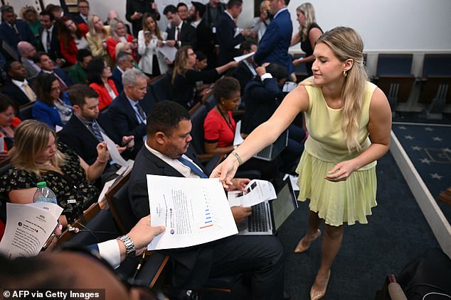 A White House staff member hands out papers reading "Making DC Safe and Beautiful Again" before US President Donald Trump arrives to speak