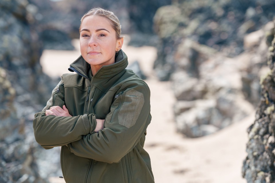 Close-up of Lucy Spraggan on a beach, arms crossed.