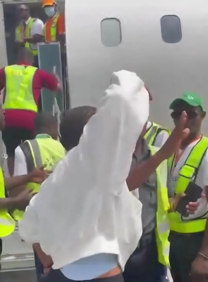 A passenger being removed from a plane after a fight with a flight attendant.