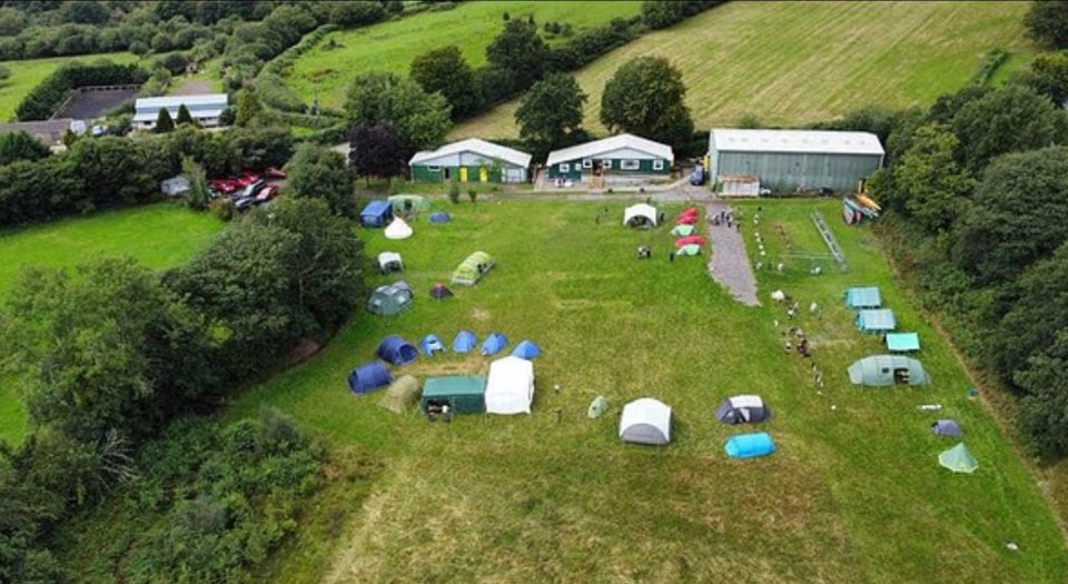 Aerial view of a scout camp with tents and buildings.