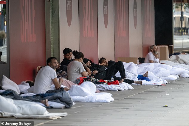 The group, which set up camp outside the shopping destination's John Lewis, were seen in a line sitting on their duvets as they rested and smoked cigarettes in July