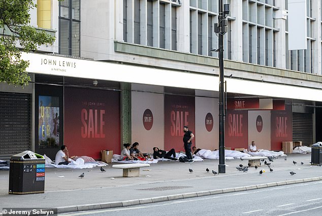 Migrants sleeping in new white duvets outside John Lewis on London's Oxford Street in July