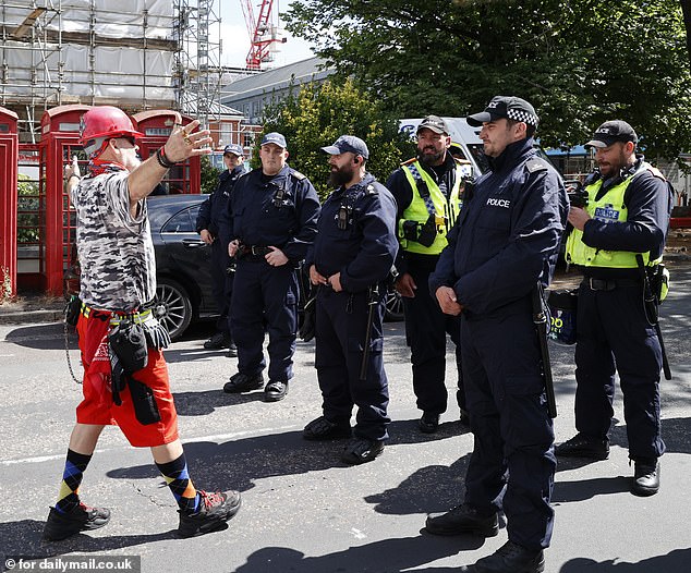 One protester in a hard hat approaches police during a protest outside Bournemouth's migrant hotels