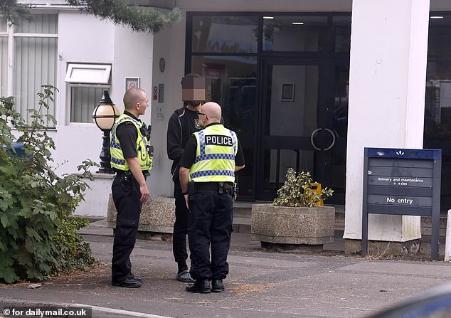 Police are patrolling the streets, both on foot and in vehicles - some of them unmarked - and officers can be seen in deep discussion with hotel residents (above) and the security guards stationed outside