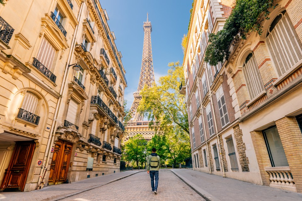 Man walking toward the Eiffel Tower in Paris.