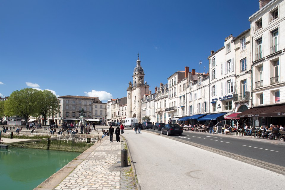 La Rochelle, France: city street scene with waterfront, clock tower, and outdoor cafes.