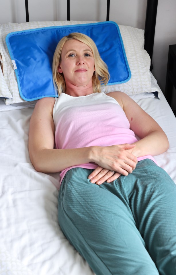 Woman lying in bed using a cooling pillow.
