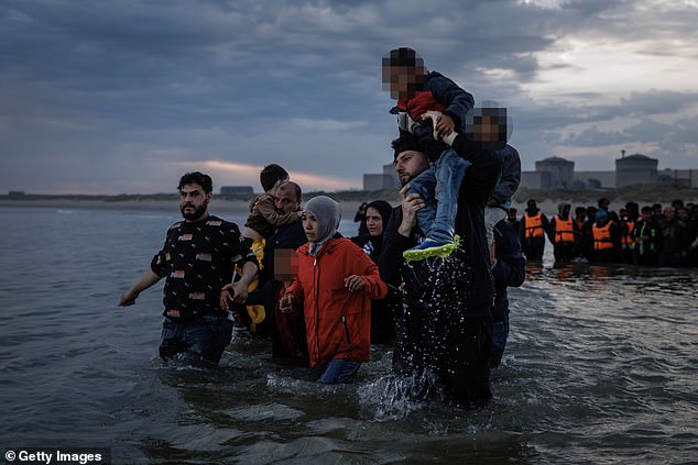 A group of migrants wading into the sea towards a smugglers boat this morning