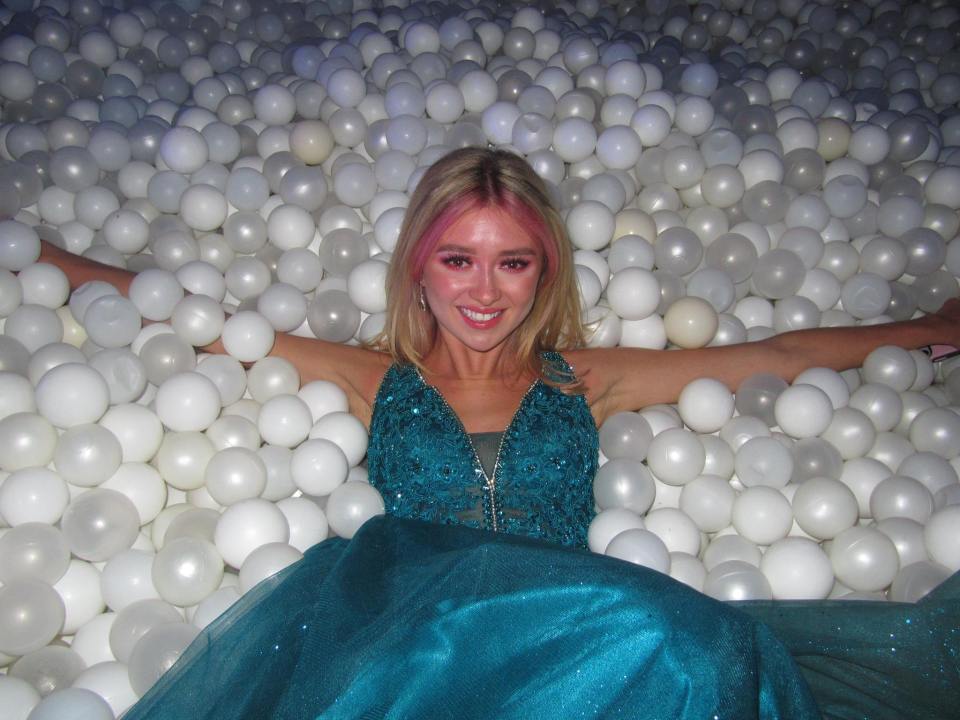 Woman in teal dress in ball pit.