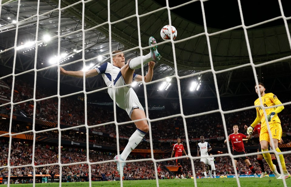 Tottenham Hotspur's Micky van de Ven kicks a soccer ball into the goal.