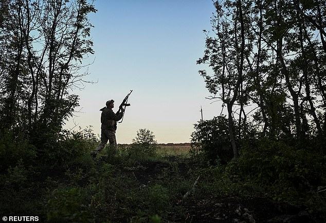 A serviceman of 152nd Separate Jaeger Brigade of the Ukrainian Armed Forces checks the sky to look out for Russian combat drones, near the town of Pokrovsk in Donetsk region, Ukraine August 5, 2025