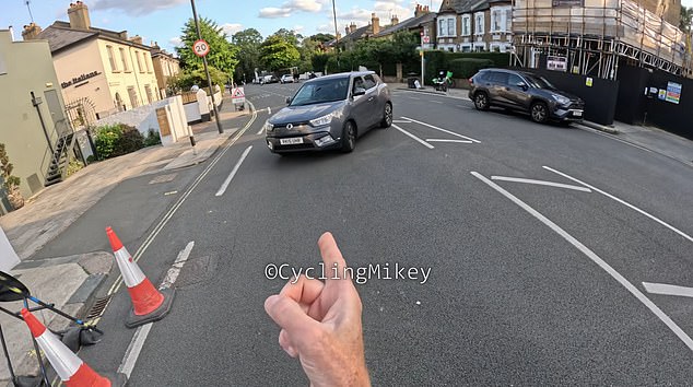 As one grey car travelled down the road, Cycling Mikey drove in front of it to act as a barrier, forcing the driver to turn around as he told them off with a hand gesture