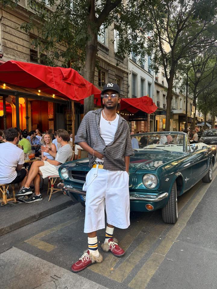 Man standing by a vintage car in Paris.