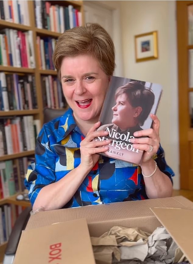 Former SNP leader Sturgeon has been in a public war of words with the Harry Potter author for years over their clashing views on transgender issues (Sturgeon is seen unboxing a copy of her autobiography, Frankly)