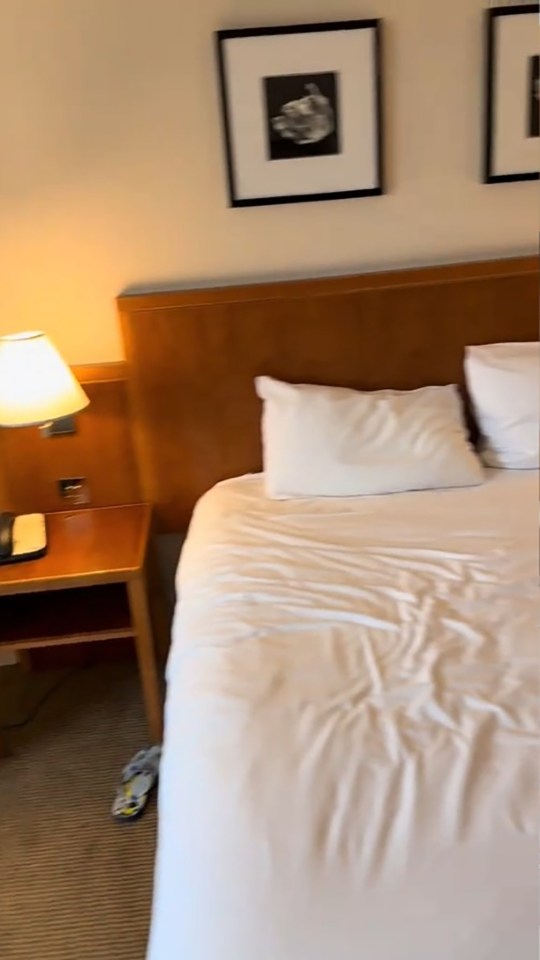 Hotel room with bed and nightstand.