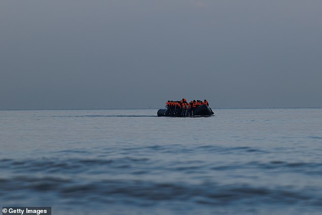 A small boat arrives to collect migrant families from the beach on August 12, 2025
