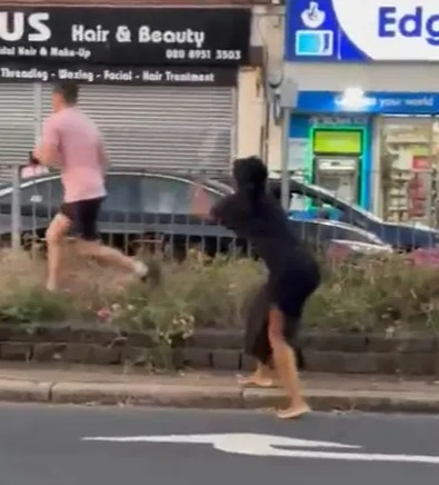 Road rage incident: a man and woman fighting in the street.