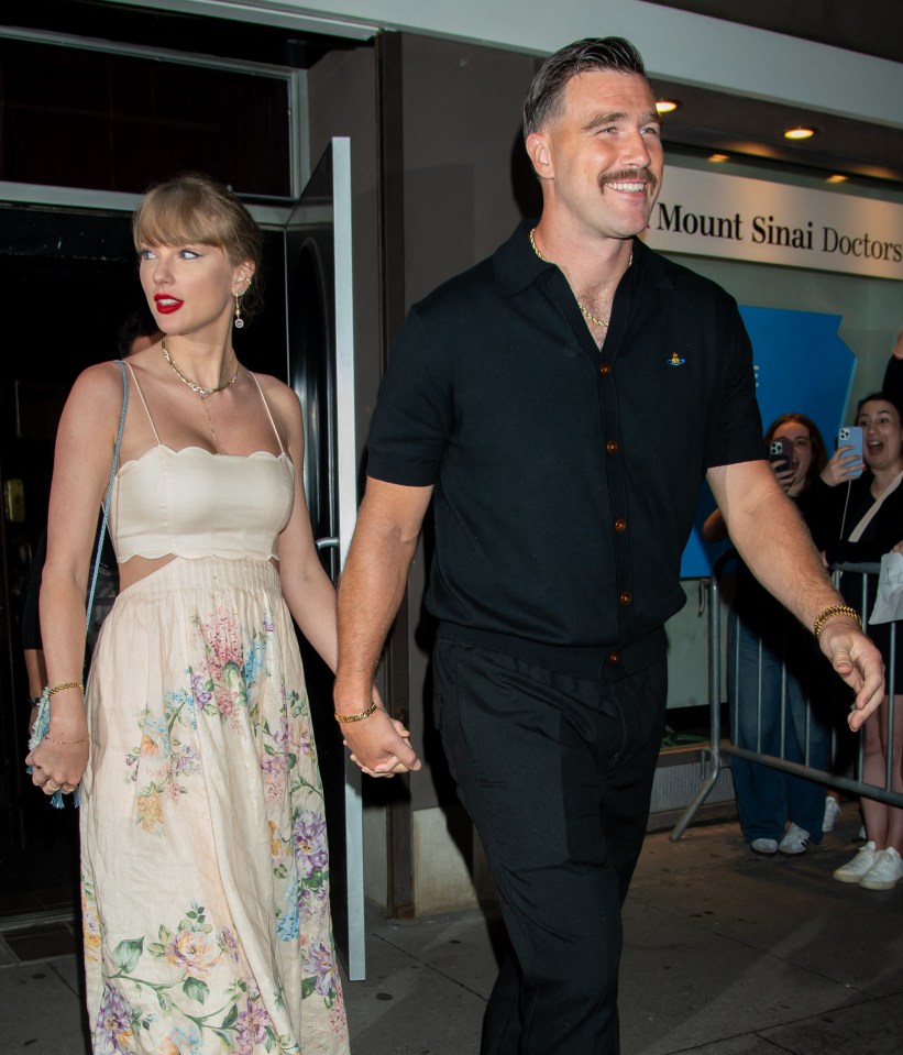 Taylor Swift and Travis Kelce holding hands.