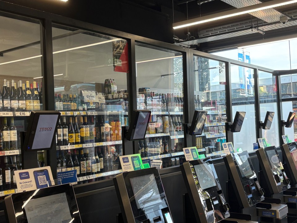 Alcohol and beer in a Tesco Express store are behind a protective glass partition at the self-checkout.