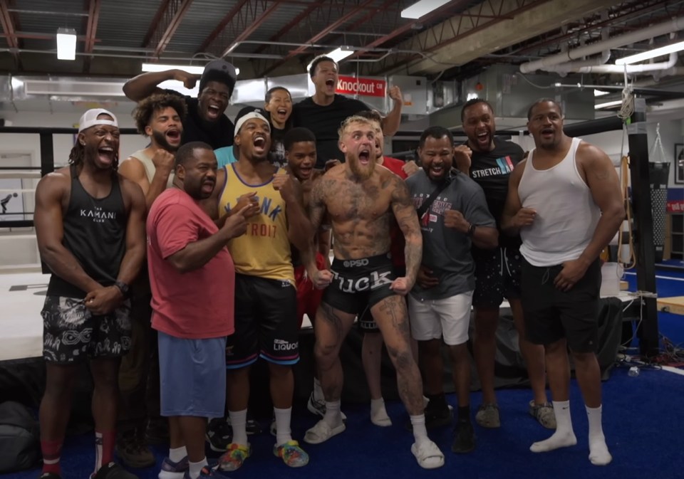 Group of people celebrating in a boxing gym.