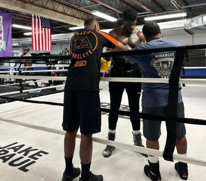 Boxer with his trainers in a boxing ring.