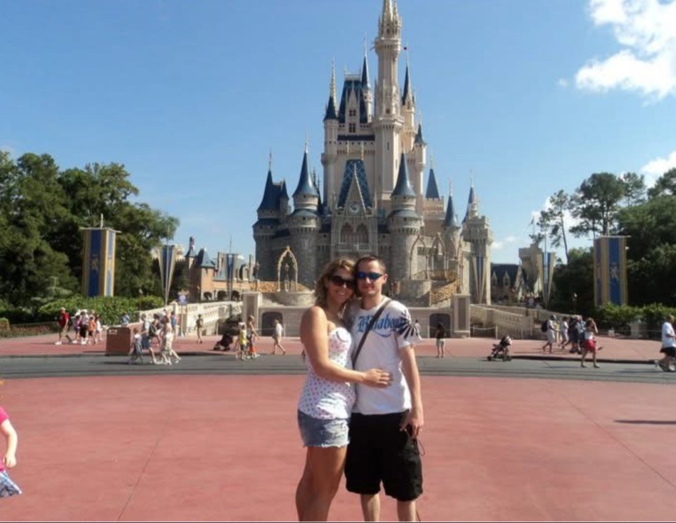 Couple posing in front of Cinderella Castle at Disney World.