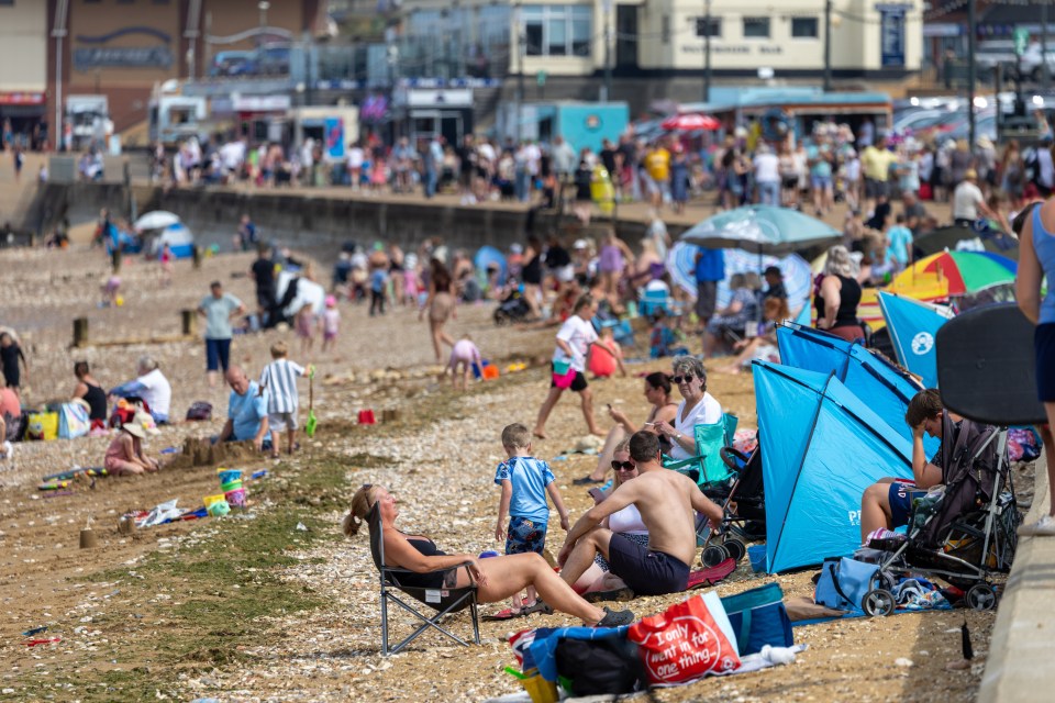 People sunbathing and swimming at an outdoor pool.