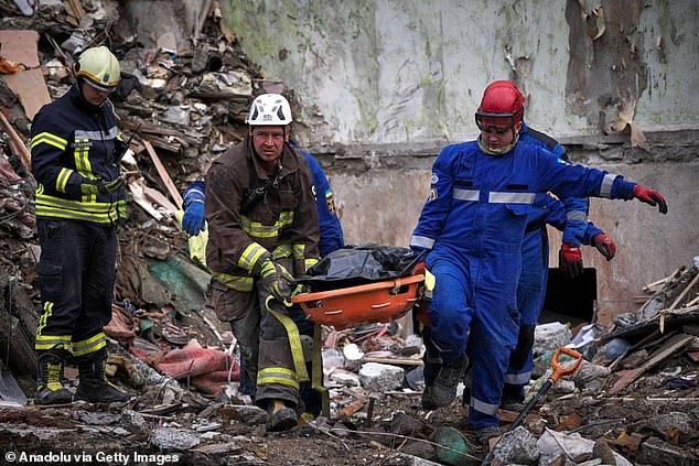 Emergency workers carrying the bodies of people killed in Russian strikes last month