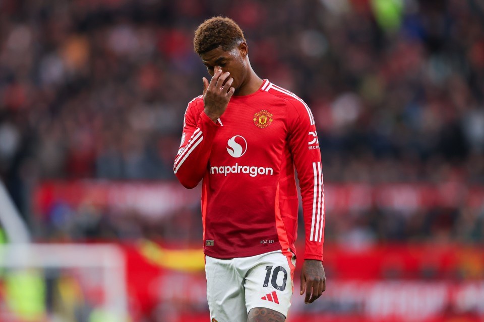 Soccer player Marcus Rashford in a Manchester United jersey looking dejected.