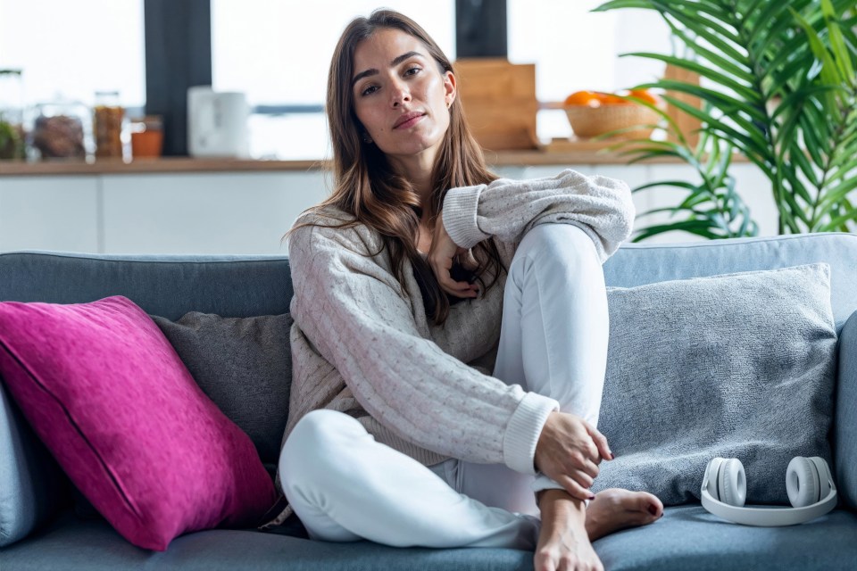 Woman sitting on a couch looking at the camera.