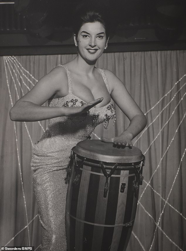 Another Cabaret Club showgirl bangs a drum for her moment in front of the camera