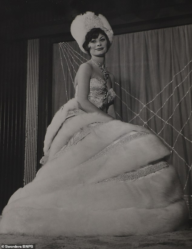 A Cabaret Club showgirl poses up a storm in a fur-lined dress