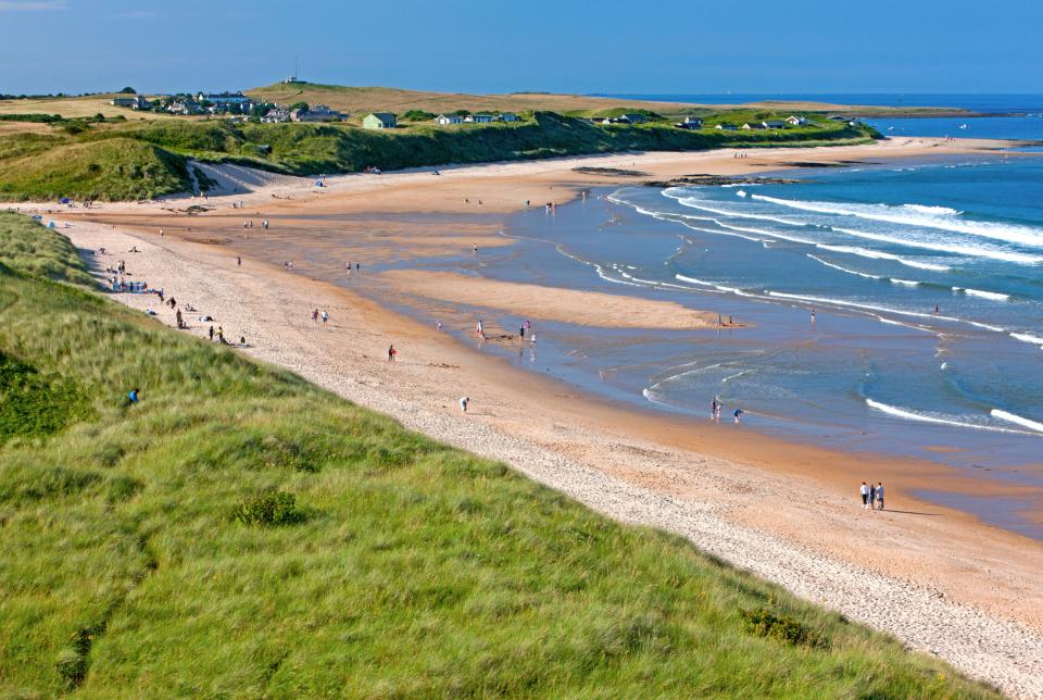 Aerial view of Embleton Bay beach in Northumberland, with people enjoying the sand and surf.