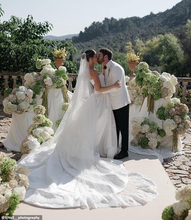 The newlyweds looked happier than ever as they said 'I do' surrounded by white and green flowers overlooking the mountains