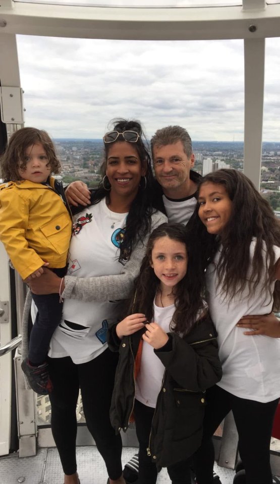 A family of five posing in a Ferris wheel capsule.