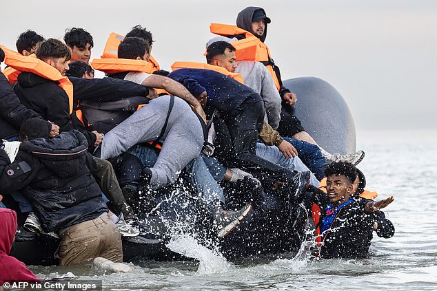 Migrants, mostly male, scrambled to get aboard the inflatable, pictured off Gravelines beach in France yesterday