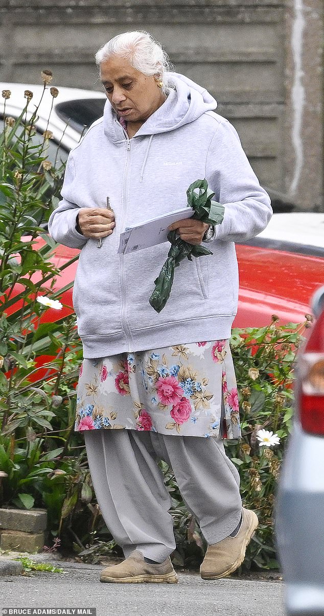Mr Kohli¿s wife, Satinder Kaur, carries some of the condolence cards left by other mourners