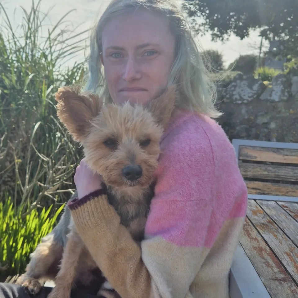 Photo of Tia-Mae McCarthy holding a small dog.