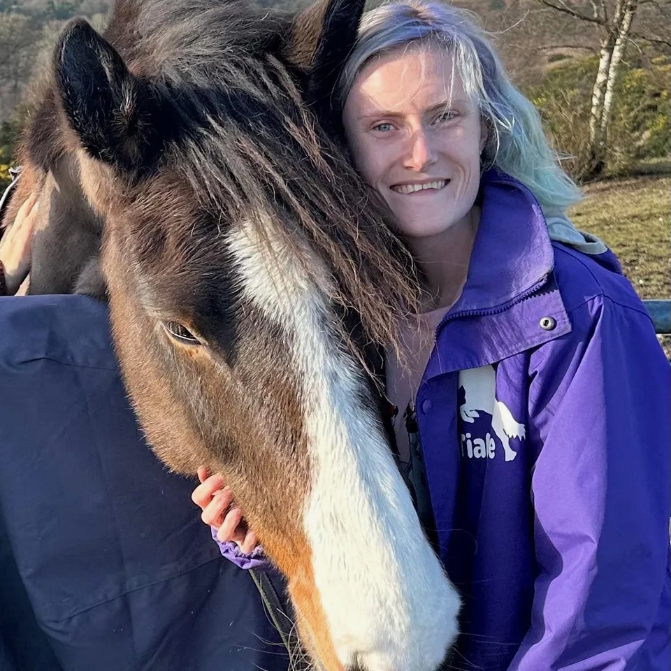 Photo of Tia-Mae McCarthy hugging a horse.