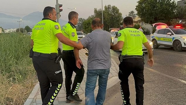 A photo shows three police officers taking a suspect, who was allegedly under the influence, into custody
