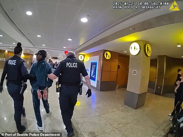 Richardson is led out of the airport in handcuffs after being detailed by Seattle police officers