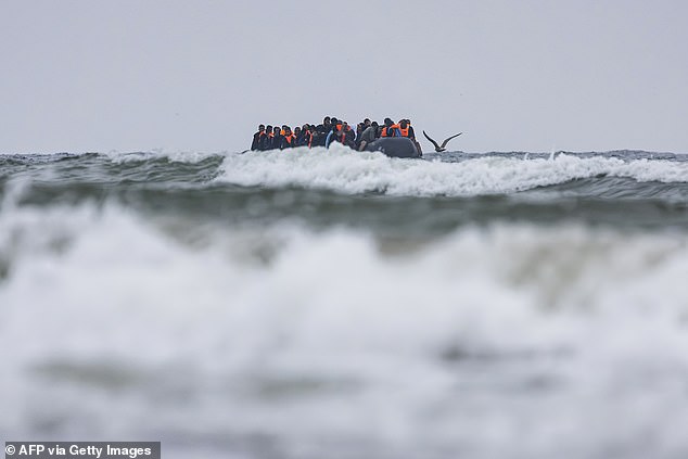 Migrants leave a beach in northern France in a smuggler's boat yesterday