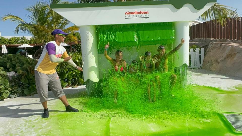 People being drenched with green slime at a Nickelodeon Hotels & Resorts water park.